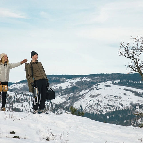 a couple on a snowy hill with snow peak x rumpl nanoloft takibi blanket