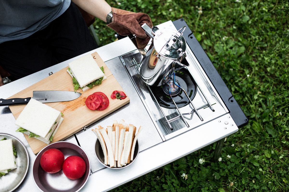 Preparing food at a Snow Peak IGT camp kitchen with flat burner