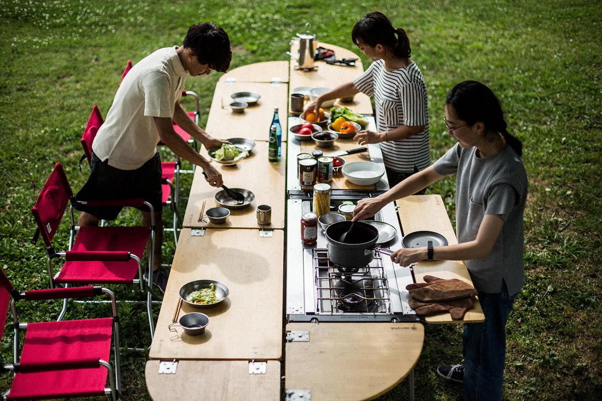 Snow Peak Iron Grill Table (IGT) kitchen counter table with people cooking food